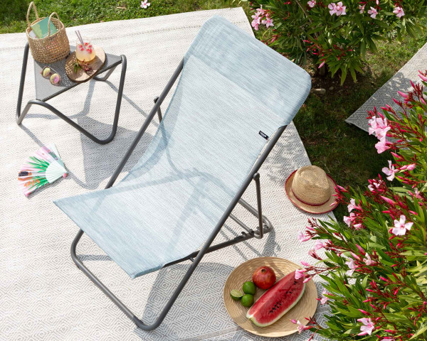 Lafuma Liegestuhl in der Farbe Eva zusammen mit Beistelltisch Vogue Titan auf Outdoor Teppich Melya - bowi.ch